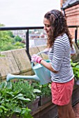 THE BALCONY GARDENER - ISABELLE PALMER WATERING PLANTS ON HER BALCONY