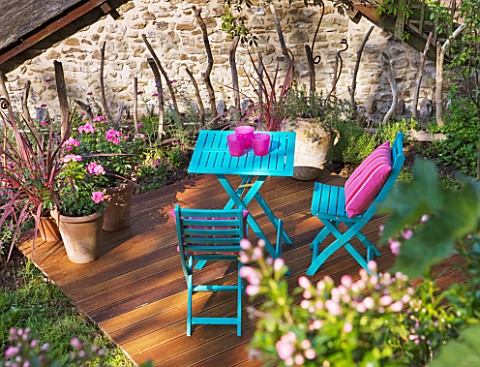 DECKING_PROJECT__DESIGNER_CLARE_MATTHEWS__WOODEN_DECK_WITH_BLUE_TABLE_AND_CHAIRS_AND_PINK_CUSHIONS