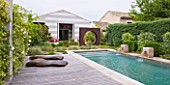 DESIGNER DOMINIQUE LAFOURCADE  PROVENCE  FRANCE: MODERN CONTEMPORARY GARDEN - DECKING  METAL OCULUS CIRCLE AND SWIMMING POOL BEYOND WITH FOUR BRICK WATER SPOUTS