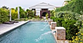DESIGNER DOMINIQUE LAFOURCADE  PROVENCE  FRANCE: MODERN CONTEMPORARY GARDEN - DECKING  METAL OCULUS CIRCLE AND SWIMMING POOL BEYOND WITH FOUR BRICK WATER SPOUTS