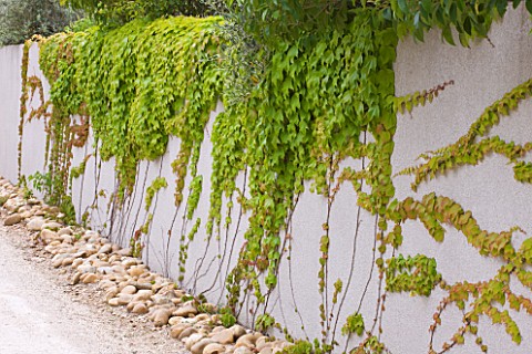 DESIGNER_DOMINIQUE_LAFOURCADE__PROVENCE__FRANCE_WALL_ALONG_DRIVE_WITH_ROUND_STONES_AT_BASE