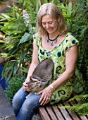 KARLA NEWELL GARDEN  BRIGHTON: KARLA SITS IN THE GARDEN WITH CAT MIXIE