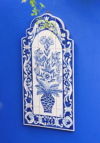 KARLA_NEWELL_GARDEN__BRIGHTON_SMALL_TOWN_GARDEN__BLUE_PAINTED_WALL_WITH_TILED_PICTURE_BOUGHT_IN_PORT