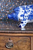 CHANTAL COADY HOUSE  LONDON: A BLUE AND WHITE PAINTED PIGGY BANK ON AN ANTIQUE CHEST OF DRAWERS IN THE MAIN BEDROOM