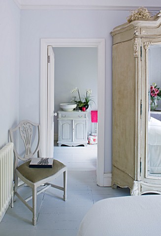 DESIGNER_JACKY_HOBBS__LONDON__WHITE_BEDROOM_AT_CHRISTMAS_WITH_MIRROR_FRONTED_WARDROBE_AND_VIEW_THROU
