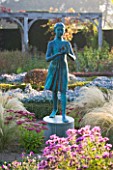 WATERPERRY GARDENS  OXFORDSHIRE: THE HEDGED IN FORMAL GARDEN AT DAWN WITH BOX AND BERBERIS HEDGING AND TOPIARY - GIRL STATUE CALLED THE LAMP OF WISDOM