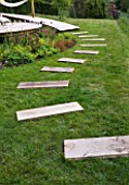 DESIGNER: CLARE MATTHEWS - STEPPING STONE PROJECT - PIECES OF OAK LAID INTO LAWN AS STEPPING STONES