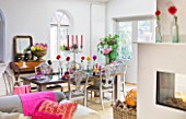 JACKY HOBBS HOUSE  LONDON: RICH AUTUMN FLOWERS IN THE COOL GREY SITTING ROOM ; BRIGHT DAHLIAS  CUSHIONS AND THROWS. DINING TABLE SET WITH FLOWERS FOR SEASONAL SUPPER. LOG FIRE.