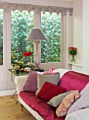 JACKY HOBBS HOUSE  LONDON: RICH AUTUMN FLOWERS AND ACCESSORIES BRING SEASONAL WARMTH TO THE COOL GREY SITTING ROOM ; BRIGHT DAHLIAS  CUSHIONS AND THROWS