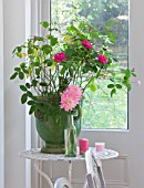 JACKY HOBBS HOUSE  LONDON: VINTAGE FRENCH BOTTLE VASE OF PINK DAHLIA GAY PRINCESS WITH PINK CANDLES AND LARGE VINTAGE GREEN FRENCH URN WITH ROSA GERTRUDE JEKYLL