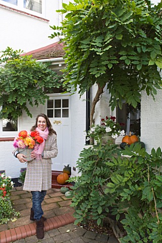 JACKY_HOBBS_HOUSE__LONDON_JACKY_HOBBS_WITH_BUCKET_FULL_OF_BRIGHT_AUTUMNAL_DAHLIA_BLOOMS_OUTSIDE_HER_