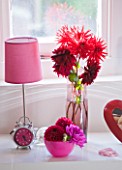 JACKY HOBBS HOUSE  LONDON: BEDROOM WITH DISPLAY OF DEEP PINK AND RED DAHLIAS AND PINK ALARM CLOCK AND LAMP