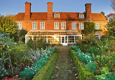 SALING_HALL__ESSEX__BRICK_PATH_LEADING_TO_HOUSE_AND_CONSERVATORY__EVENING_LIGHT