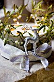 CHRISTMAS CAKE WITH REINDEER  CANDLES AND MISTLETOE IN WINDOWSILL: STYLING BY JACKY HOBBS