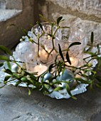 TRAY WITH CANDLES  BAUBLES AND MISTLETOE IN WINDOWSILL: STYLING BY JACKY HOBBS