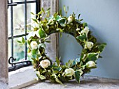 WREATH WITH IVY  ROSES AND MISTLETOE IN WINDOWSILL : STYLING BY JACKY HOBBS