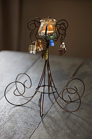 ROQUELIN__LOIRE_VALLEY__FRANCE_DINING_ROOM_GREY_WOODEN_TABLE_WITH_DECORATIVE_WIREWORK_TEA_LIGHT_HOLD