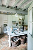 ROQUELIN  LOIRE VALLEY  FRANCE: BATHROOM; A CONVERTED MANGER  BEAMED CEILING  DECORATIVE CENTRAL TABLE WITH COLLECTIONS OF PEBBLES AND SHELLS IN GLASS JARS  BASKETS OF DRIFTWOOD