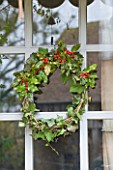 ROQUELIN  LOIRE VALLEY  FRANCE: OUTSIDE WINDOW; SIMPLE HOLLY AND BERRY WREATH  GATHERED FROM GARDEN CUTTINGS