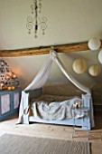 ROQUELIN  LOIRE VALLEY  FRANCE: BEDROOM; CANOPIED FRENCH PAINTED WOODEN BED WITH BEAMED CEILING AND PAPER LANTERNS