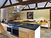 RICKYARD BARN HOUSE  OXFORDSHIRE: DESIGNERS JANE AND CLIVE NICHOLS. KITCHEN WITH SEPIA TONE PHOTO CANVAS BY CLIVE NICHOLS ON KITCHEN WALL WITH DRIED FRUIT DISPLAY ON TABLE