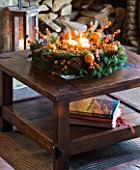 RICKYARD BARN HOUSE  OXFORDSHIRE: DESIGNERS JANE AND CLIVE NICHOLS. LIVING ROOM AT CHRISTMAS WITH CANDLE WREATH ON GLASS TOPPED COFFEE TABLE