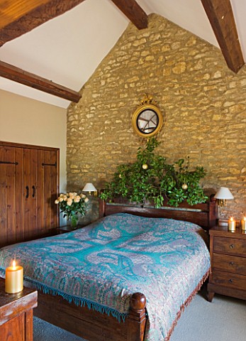 RICKYARD_BARN__OXFORDSHIRE_CHRISTMAS__BEDROOM__GOLD_LEAF_EAGLE_MIRROR_ABOVE_BED__BLUE_BED_SPREAD_AND