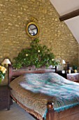 RICKYARD BARN  OXFORDSHIRE: CHRISTMAS - BEDROOM - GOLD LEAF EAGLE MIRROR ABOVE BED  BLUE BED SPREAD AND IVY DECORATED HEADBOARD