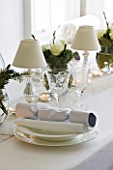 WHITE HOUSE: WHITE DINING TABLE DRESSED IN WHITE LINEN  WHITE CHINA AND SET WITH WHITE ROSES AND SEASONAL CHRISTMAS FOLIAGE