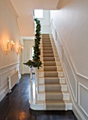 WHITE HOUSE: RECEPTION HALL: MAIN STAIRCASE  WHITE PANELLED WALLS  BANISTER DRESSED WITH CHRISTMAS PINE AND CONE GARLAND