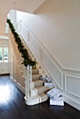 WHITE HOUSE: RECEPTION HALL: MAIN STAIRCASE  WHITE PANELLED WALLS  BANISTER DRESSED WITH CHRISTMAS PINE AND CONE GARLAND