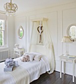 WHITE HOUSE: GIRLS BEDROOM WITH WHITE WALL PANELLING  OVAL WALL MIRRORS  CROWN STYLE LIGHT  SWEDISH STYLE IVORY PAINTED WOODEN BED WITH SHEER CANOPY   WHITE BED LINEN