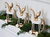 WHITE HOUSE: GIRLS BEDROOM - CHRISTMAS MANTELPIECE DISPLAY - FRESH PINE TRIMMINGS AND THREE WHITE AND GOLD WOODEN WHEELED HORSES