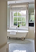 WHITE HOUSE: VIEW INTO MASTER BATHROOM - CREAM WITH MARBLE FLOORS  WHITE ROLL TOP BATH.
