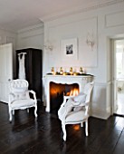WHITE HOUSE: MASTER BEDROOM - WHITE WITH DARK WOOD FLOORING  FIREPLACE AND OCCASIONAL WHITE LINEN  BUTTON BACK CHAIRS