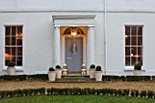 WHITE HOUSE: PALE GREY FRONT DOOR DECORATED WITH WHITE GYPSOPHILA CHRISTMAS WREATH AND METAL LANTERNS