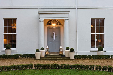 WHITE_HOUSE_PALE_GREY_FRONT_DOOR_DECORATED_WITH_WHITE_GYPSOPHILA_CHRISTMAS_WREATH_AND_METAL_LANTERNS