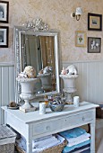 SARAH BAKERS HOUSE  THE OLD VICARAGE: BATHROOM WITH SHELVED CONSOLE  VINTAGE MIRROR AND SHELLS DISPLAYED IN VINTAGE GARDEN URNS.