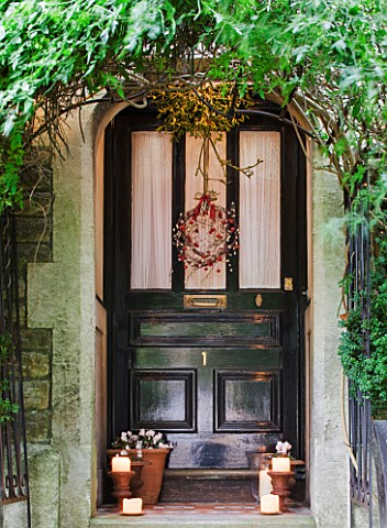 SARAH_BAKERS_HOUSE__THE_OLD_VICARAGE_FRONT_DOOR_DRESSED_WITH_MISTLETOE_BALL_AND_BERRIED_WREATHPLANTE