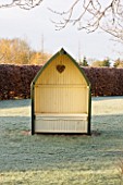THE MANOR HOUSE  STEVINGTON  BEDFORDSHIRE. DESIGNER: KATHY BROWN: SENTRY HUT / GARDEN SEAT/BENCH IN THE ORCHARD IN FROST. WINTER