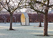 THE MANOR HOUSE  STEVINGTON  BEDFORDSHIRE. DESIGNER: KATHY BROWN: SENTRY HUT / GARDEN SEAT/BENCH IN THE ORCHARD IN FROST. WINTER