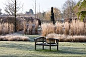 THE MANOR HOUSE  STEVINGTON  BEDFORDSHIRE. DESIGNER: KATHY BROWN: THE MONET AND MONDRIAN BORDER IN WINTER WITH WOODEN BENCH/SEAT IN FROST. WINTER
