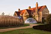 THE MANOR HOUSE  STEVINGTON  BEDFORDSHIRE. DESIGNER: KATHY BROWN: EVENING LIGHT ON THE MANOR HOUSE WITH THE SOLARDOME AND HOKUSAI  WAVE BORDER