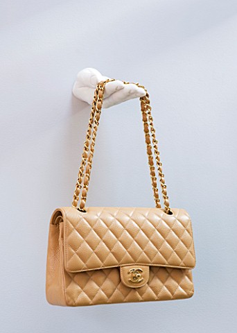 TARA_NASHKING_HOUSE__LONDON_ICONIC_CHANEL_BAG_DISPLAYED_ON_SCULPTED_HAND_ON_WALL_IN_LIVING_ROOM