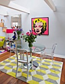 TARA NASH-KING HOUSE  LONDON: THE DINING AREA IN THE HOME OF CLOTHES DEALER TARA NASH-KING. TABLE  CHAIRS  MARILYN MONROE PRINT ON WALL