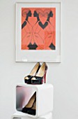 TARA NASH-KING HOUSE  LONDON: SHOES ON DISPLAY SHELVING BENEATH ILLUSTRATION FROM HERMES FASHION HOUSE IN THE LIVING ROOM