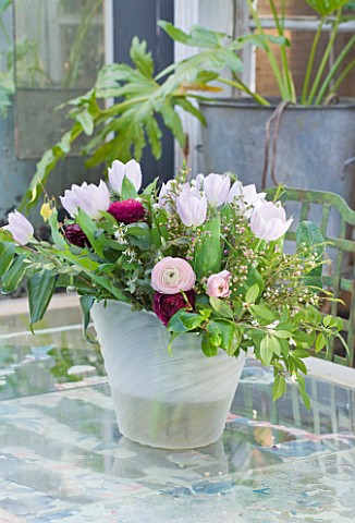 PETERSHAM_NURSERIES__RICHMOND__SURREY_CONTAINER_WITH_FLOWERS_OF_RANUNCULUS_AND_TULIPS