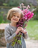 HERM ISLAND  CHANNEL ISLANDS - GIRL HOLDING A BOUQUET OF FLOWERS IN PINK - GLADIOLUS COMMUNIS BYZANTINUS AND RED CAMPION