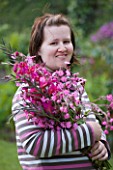 HERM ISLAND  CHANNEL ISLANDS - BRETT MORES WIFE WITH BOUQUET OF PINK FLOWERS - GLADIOLUS COMMUNIS BYZANTINUS AND RED CAMPION