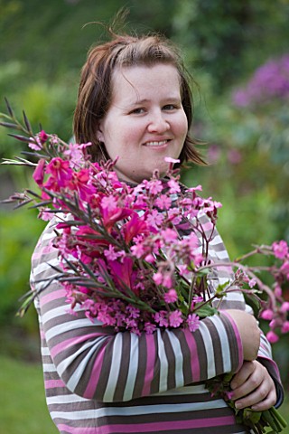 HERM_ISLAND__CHANNEL_ISLANDS__BRETT_MORES_WIFE_WITH_BOUQUET_OF_PINK_FLOWERS__GLADIOLUS_COMMUNIS_BYZA